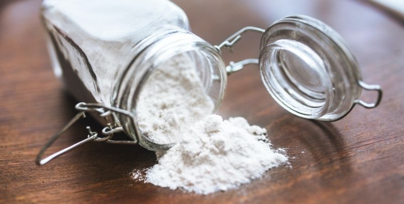 A jar of flour is neatly tipped over.
