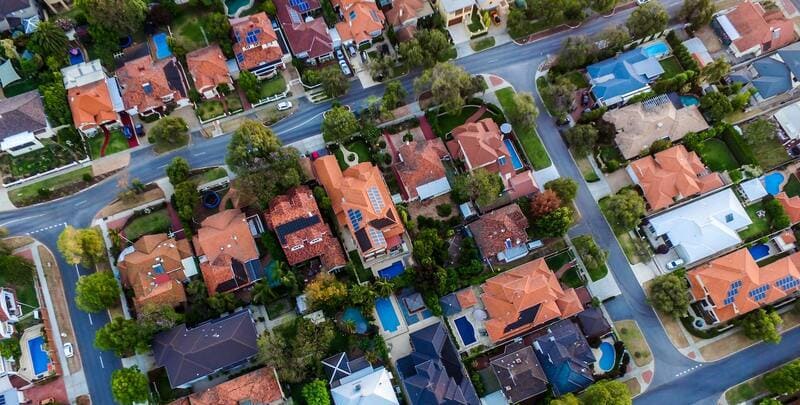 Aerial shot of a number of house roofs in a typical suburban neighbourhood.