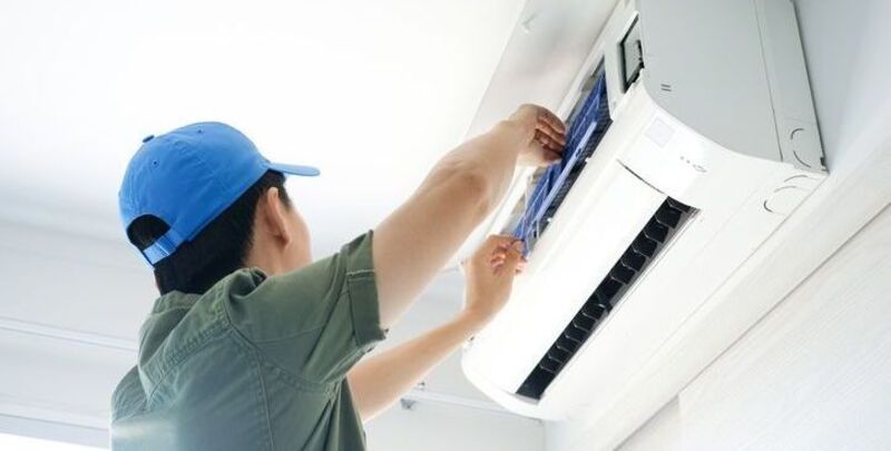 A technician works on an air conditioner
